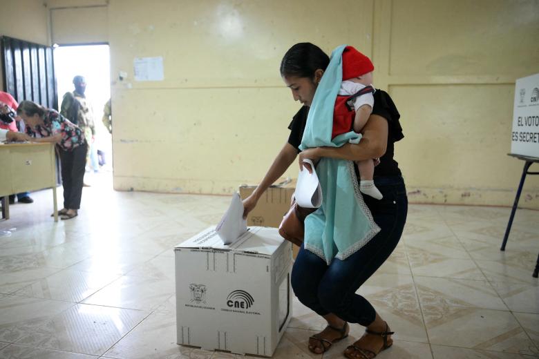 A woman with her baby casts her vote at a polling station during the presidential election in Canuto, Manabi province, Ecuador, on February 9, 2025. Some 14 million Ecuadorans began voting Sunday to decide who will lead the violence-wracked Andean nation through its worst crisis in half a century. (Photo by Rodrigo BUENDIA / AFP)