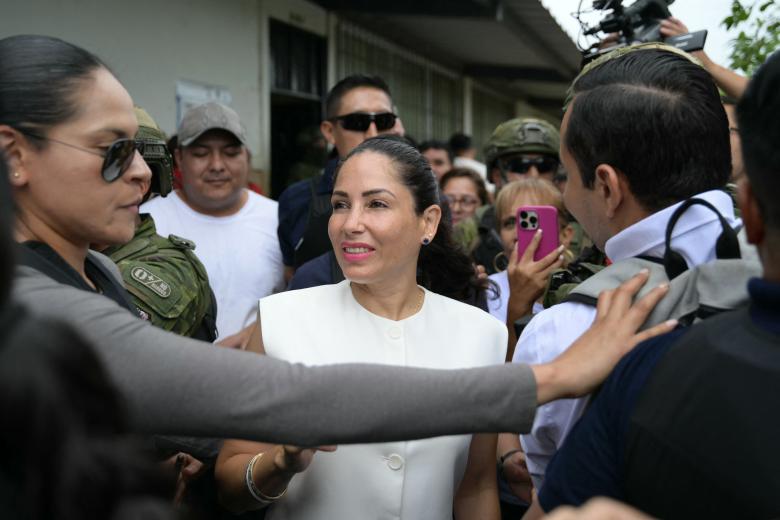 Ecuador's presidential candidate for the Movimiento Revolución Ciudadana party (Citizen Revolution Movement), Luisa Gonzalez (C), gestures as she leaves after voting at a polling station in Canuto, Ecuador, on February 9, 2025, during the presidential election. Some 14 million Ecuadorans began voting Sunday to decide who will lead the violence-wracked Andean nation through its worst crisis in half a century. (Photo by Rodrigo BUENDIA / AFP)