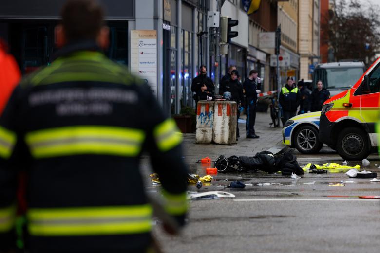 A police officer uses a dog to search the car at the scene where a man drove into a crowd in the southern German city of Munich on February 13, 2025 leaving several people injured, police said. Munich police said on social media platform X that "several people were injured" after "a car drove into a group of people" in the centre of the Bavarian state capital. (Photo by Michaela STACHE / AFP)