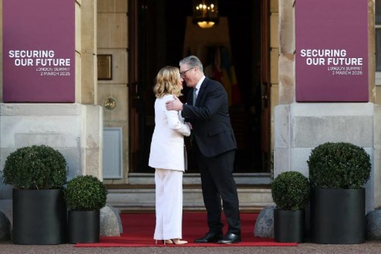 El primer ministro británico, Keir Starmer, saludando a la primera ministra de Italia, Giorgia Meloni