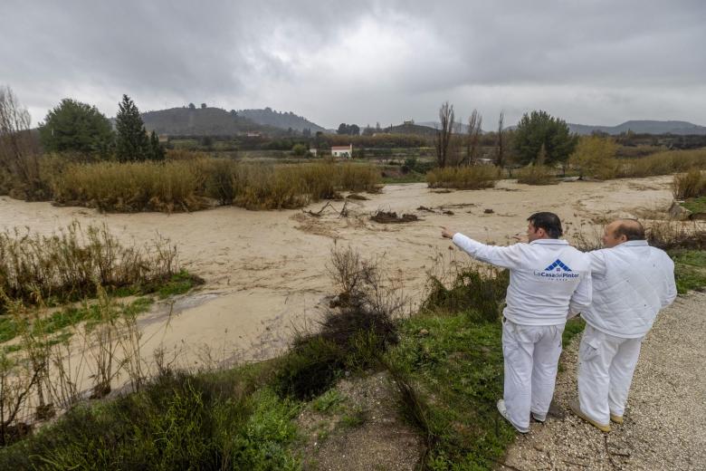 Dos hombres junto al cauce del Río Argos a su paso por el municipio de Cehegín, (Murcia), desbordado tras las fuertes lluvias caídas en las últimas horas en el municipio.