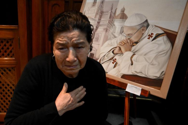Una fiel católica llora la muerte del Papa Francisco frente a una pintura del Sumo Pontífice en la Basílica de San José de Flores en Buenos Aires