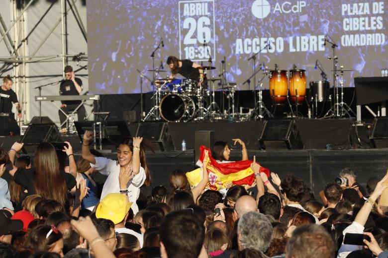 Una bandera de España y jóvenes bailando en la III Fiesta de la Resurrección