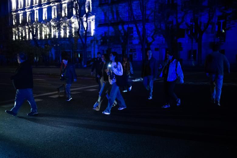 Varias personas cruzan por un paso de peatones tras el apagón eléctrico en Madrid