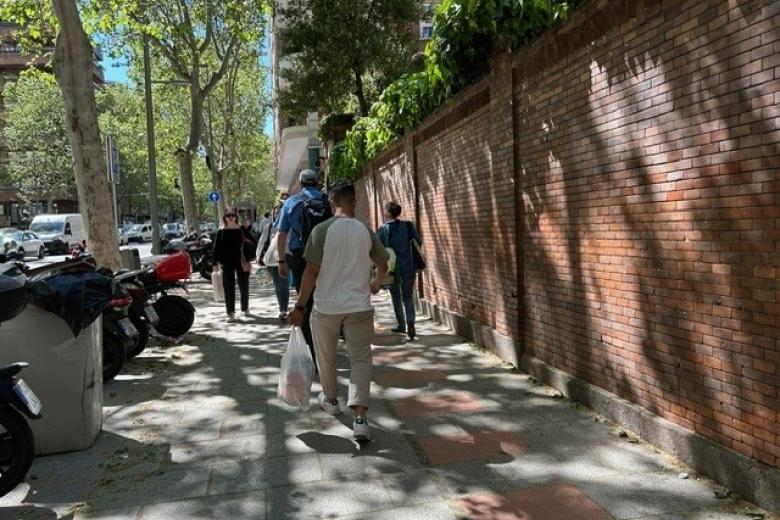 varias personas cargan con bolsas después de salir del supermercado
