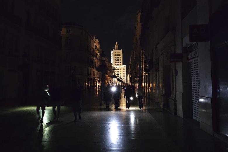 Vista de la céntrica calle Larios de Málaga, una de las más reconocidas de España, a oscuras durante la noche del lunes durante el apagón eléctrico