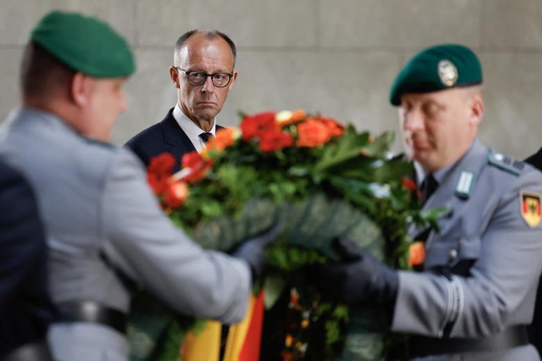 El canciller alemán, Friedrich Merz, observa a soldados portando una corona de flores el 8 de mayo de 2025 en la Neue Wache de Berlín