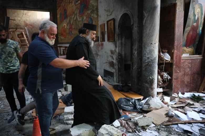 Un clérigo camina entre los escombros en el lugar del atentado