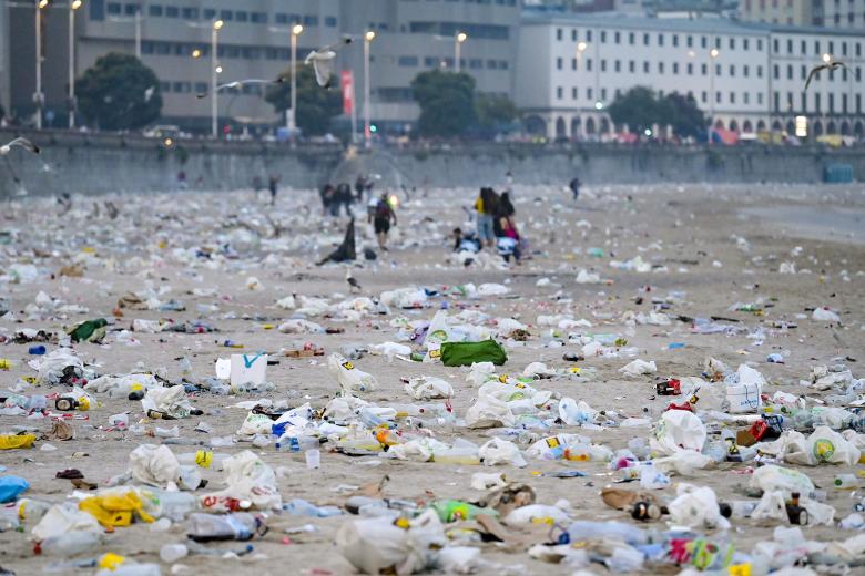 A CORUÑA, 24/06/2025.- Rescoldos de una hoguera y basura acumulada en la playa del Orzán (A Coruña) tras las celebraciones de la noche de San Juan. EFE/ Moncho Fuentes