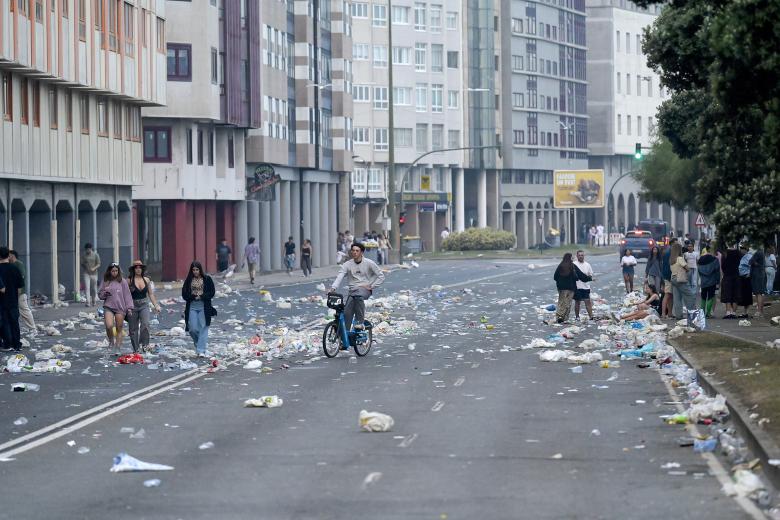 A CORUÑA, 24/06/2025.- Empleados de los servicios de limpieza recogen este martes los múltiples restos de basura acumulada en la playa del Orzán (A Coruña) tras las celebraciones de la noche de San Juan. EFE/ Moncho Fuentes