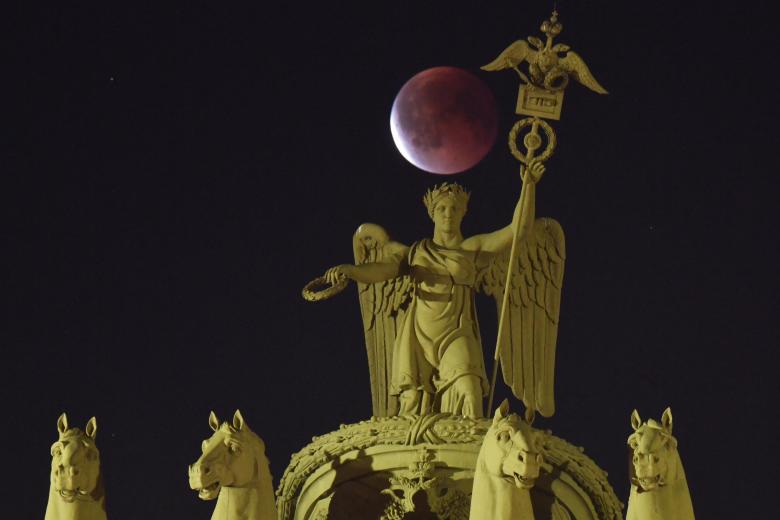 Una fase de un eclipse lunar total se observa detrás del Carro del Triunfo, en lo alto del Arco del Estado Mayor en San Petersburgo