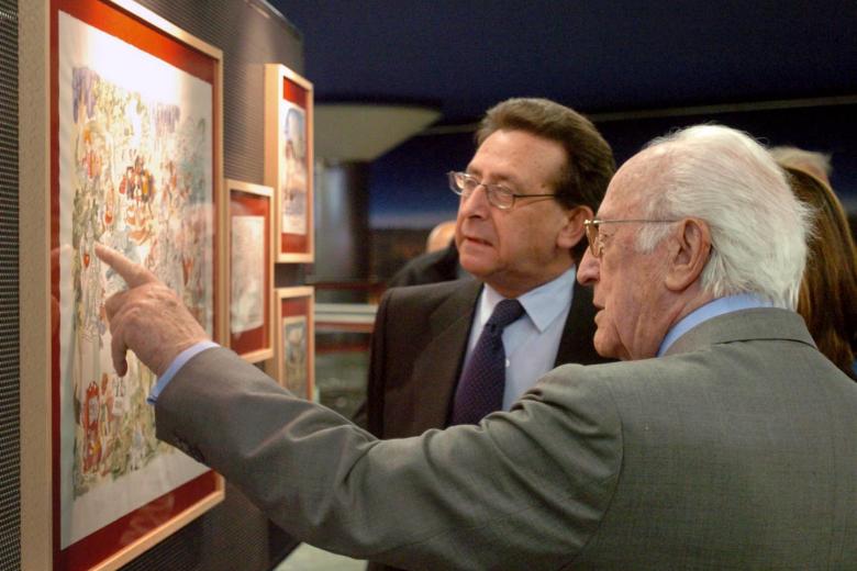 El dibujante Antonio Mingote conversa con el periodista Alfonso Ussía durante la inauguración el 19 de abril de 2005 de la muestra de dibujos de Mingote que se expuso en la estación de Nuevos Ministerios del Metro de Madrid.