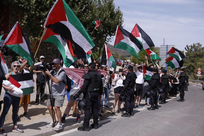 Manifestantes propalestinos antes de darse la salida de la vigésima etapa de La Vuelta a España. El grupo de corredores en cabeza tuvo que pasar por los laterales de la calzada, mientras los coches y motos quedaron bloqueados durante unos instantes.