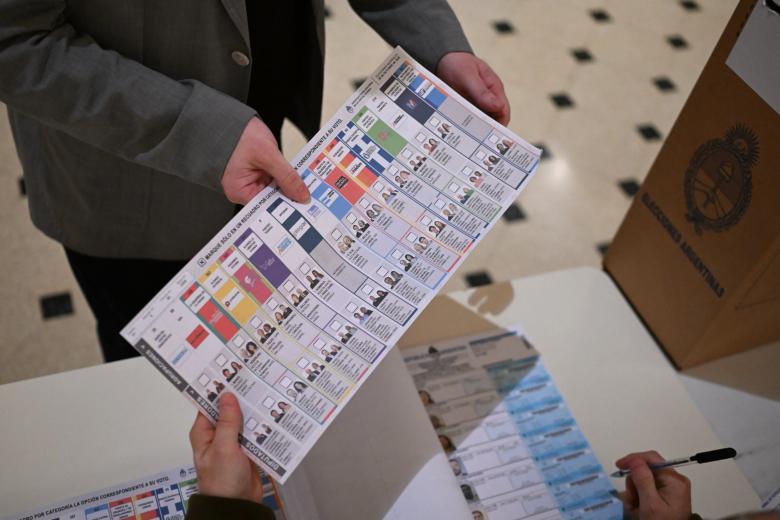 A man casts his vote at a polling station during the national midterm legislative election in Buenos Aires on October 26, 2025. Argentines head to the polls for a midterm election that will determine whether President Javier Milei enters the second half of his term bolstered or diminished as economic troubles abound despite unprecedented US aid. (Photo by Alejandro PAGNI / AFP)