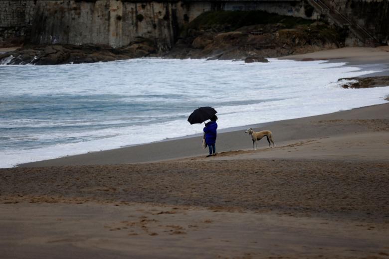 A CORUÑA (ESPAÑA), 11/11/2025.- Una mujer observaba el mar este martes desde la playa del Orzán, en A Coruña, donde la tormenta Claudia empieza a dejarse sentir con lluvias y fuertes vientos en la costa de Galicia, donde permanece activa la alerta naranja por oleaje y mar de viento en toda la costa, a excepción de la Mariña lucense, donde el qviso es de nivel amarillo. EFE/Cabalar