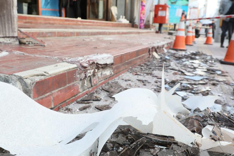 Broken window glass scattered on the street in front of a building is seen in Hachinohe City in Aomori Prefecture on December 9, 2025, following a 7.5 magnitude earthquake off northern Japan. A big quake off northern Japan left at least 30 injured, authorities said on December 9, damaging roads and leaving thousands without power in freezing temperatures. (Photo by JIJI Press / AFP) / Japan OUT / JAPAN OUT / JAPAN OUT
