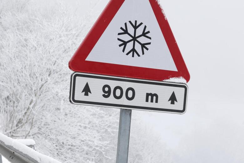 LUGO (GALICIA), 06/01/2026.- Dos personas caminan este martes, en la carretera LU-633 en el alto do Poio, Lugo (Galicia). El 112 Galicia ha registrado este martes más de una veintena de incidentes relacionados con hielo o nieve en las carreteras, en su mayoría en vías secundarias. EFE/ Eliseo Trigo
