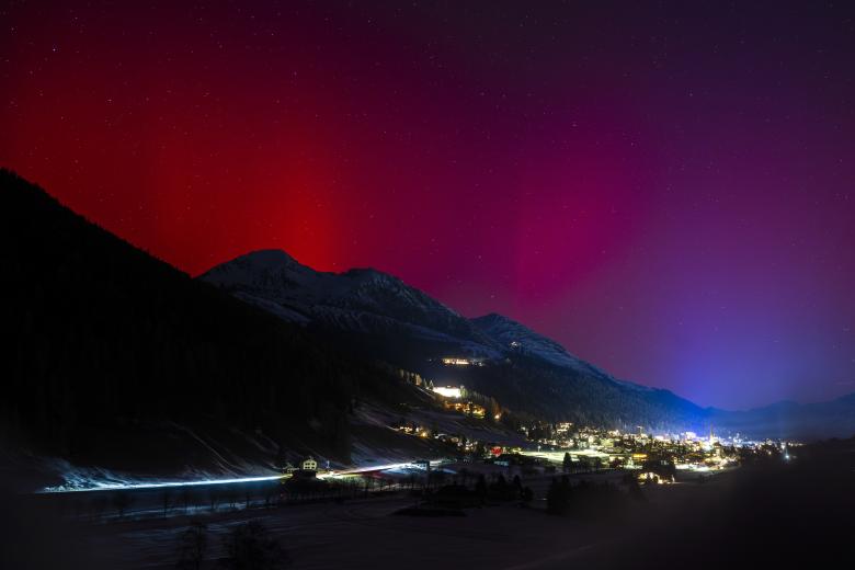 Las luces del norte (aurora boreal) brillan en el cielo nocturno sobre Davos antes de la 56.ª reunión anual del Foro Económico Mundial (FEM), en Davos, Suiza.