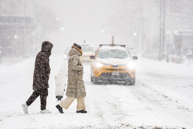 - Personas caminan durante una nevada este domingo, en Manhattan (Estados Unidos). La gran tormenta de hielo y nieve que ha afectado a dos tercios de la geografía estadounidense ha dejado este domingo a más de 700.000 hogares