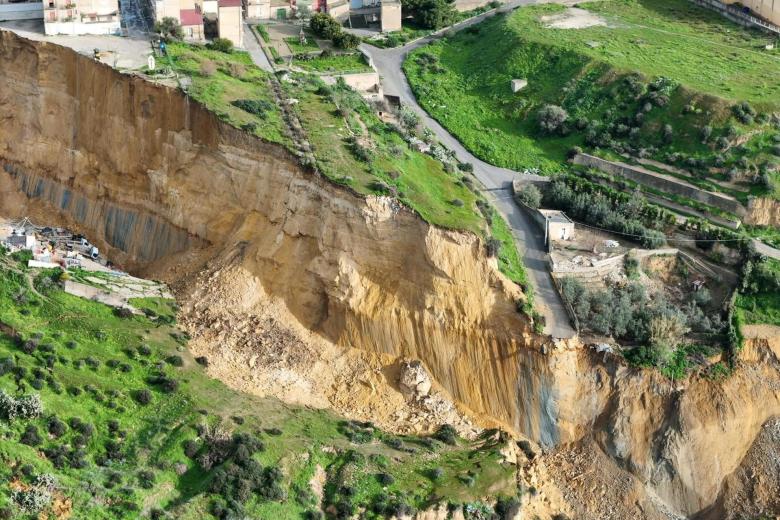 En el pabellón deportivo de Niscemi, los voluntarios de Protección Civil se preparan para gestionar una emergencia que prevén que durará mucho tiempo. Muchas personas han encontrado refugio con amigos y familiares, mientras que el resto se encuentra aquí. Permanecerán hasta que el Gobierno les proporcione una contribución temporal para ayudarles a encontrar un alquiler: 400 € por familia, más 100 € adicionales por cada miembro, hasta un total de 900 € al mes.
