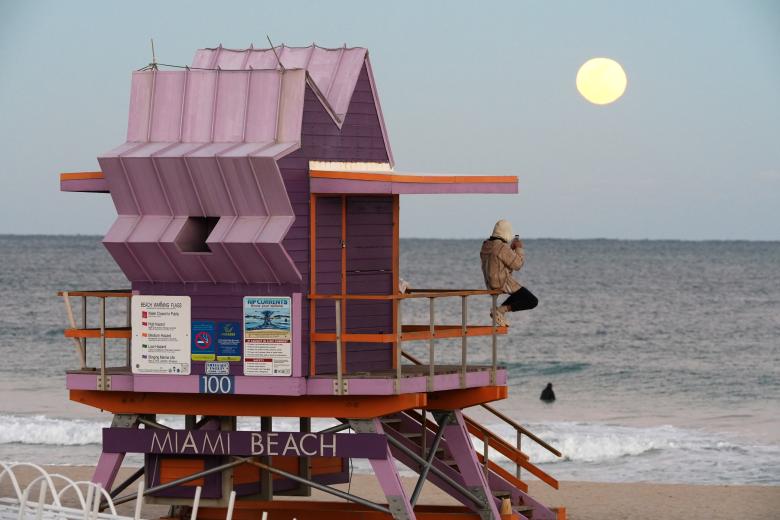 Una persona observa la Luna llena en una playa este domingo, en Miami (EE.UU.)