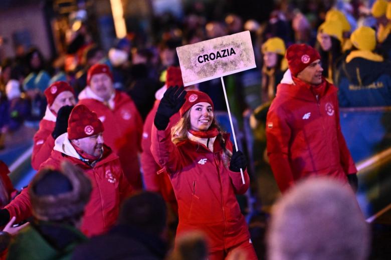 La croata Anika Kozica (centro) desfila con los miembros de la delegación de su país durante la ceremonia de apertura de los Juegos Olímpicos de Invierno Milano Cortina 2026 en Cortina d'Ampezzo.