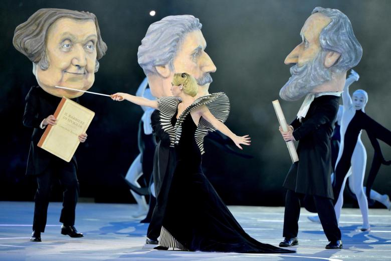 La creatividad italiana cobra forma en un desfile de iconos —desde grandes inventos hasta gastronomía, arquitectura, moda y diseño, e incluso el entretenimiento— con un homenaje a una de sus protagonistas más queridas, Raffaella Carrà, la cantante, actriz, bailarina y presentadora que revolucionó el lenguaje del entretenimiento en Italia.