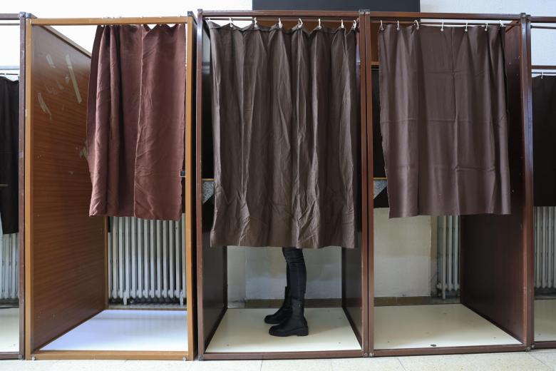 Una votante elige su papeleta antes de votar en un colegio electoral este domingo en Zaragoza.