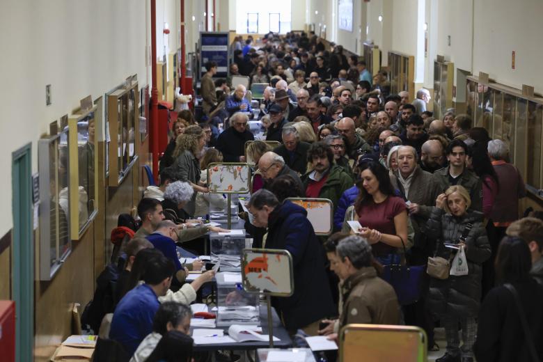 Numerosas personas acuden a votar en un colegio electoral de Zaragoza.