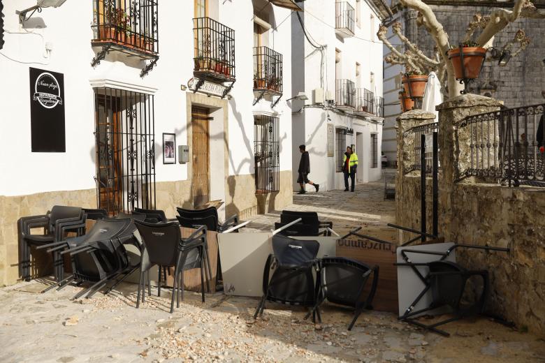 GRAZALEMA (CÁDIZ), 16/02/2026.- Sillas y mesas apiladas en una calle de Grazalema este lunes. Un primer grupo de vecinos desalojados hace 11 días por el temporal en Grazalema (Cádiz) ha podido volver a sus hogares a partir de las 16:05 horas de este lunes, cuando la Guardia Civil ha permitido el acceso a una treintena de vehículos al municipio. EFE/ Jorge Zapata