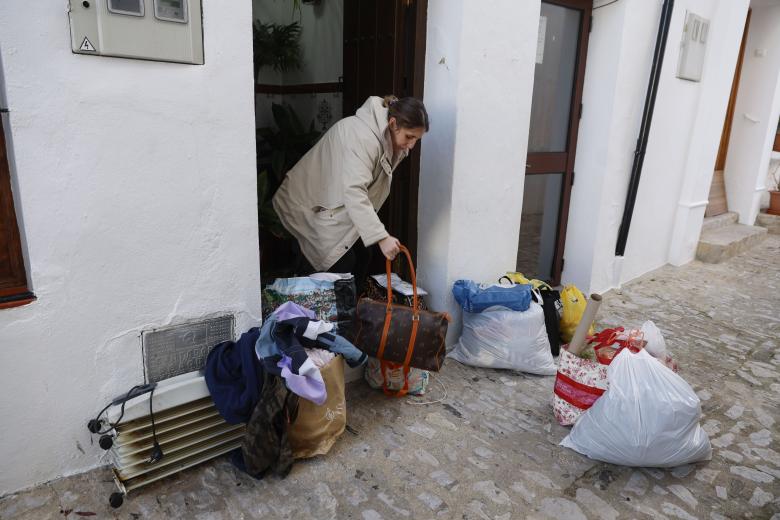 Una mujer junto a sus enseres frente a una vivienda de Grazalema este lunes