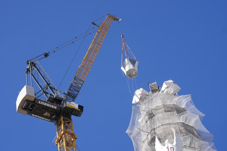 Una grúa coloca la última pieza de la torre de Jesucristo de la Sagrada Familia