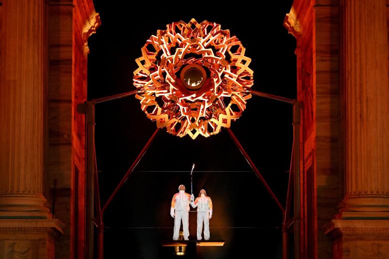 Alberto Tomba y Deborah Compagnoni sostienen la llama olímpica bajo el pebetero en el Arco della Pace, en el centro de Milán, durante la ceremonia de apertura de los Juegos Olímpicos de Invierno Milán-Cortina 2026 en Milán.