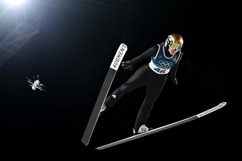 Un dron de transmisión sobrevuela a la alemana Selina Freitag mientras salta durante la primera ronda del salto de esquí individual femenino en los Juegos Olímpicos de Invierno Milán-Cortina 2026