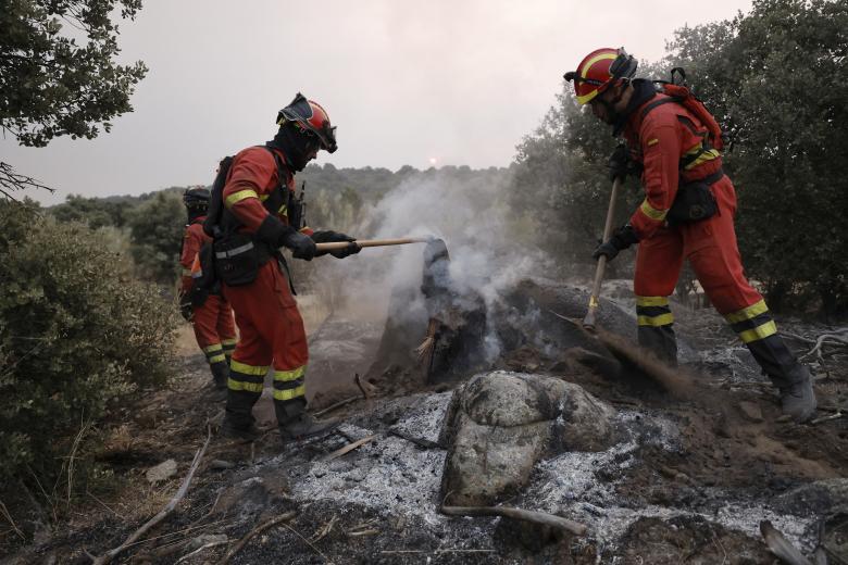 Los bomberos luchan contra un incendio forestal en la zona de Zarzalejo, cerca de El Escorial
