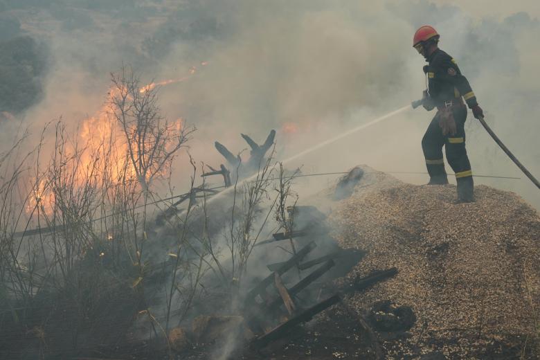 Un bombero riega los escombros mientras combate un incendio forestal en la zona de Cebreros, cerca de Ávila