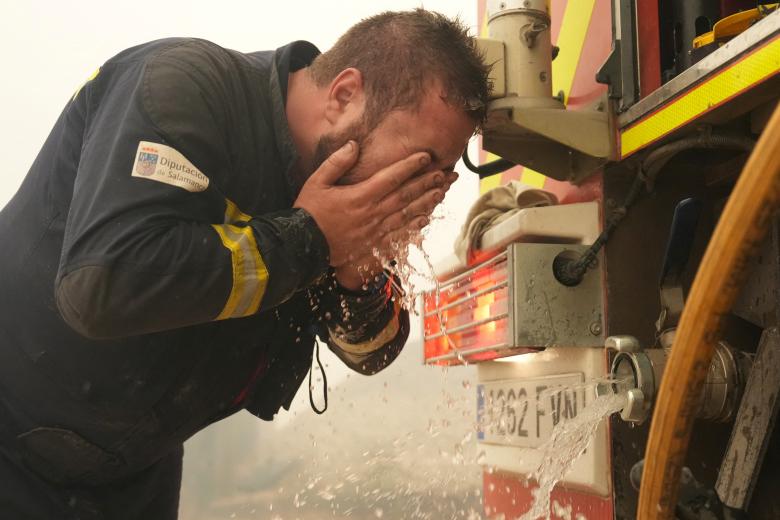 Un bombero de la unidad de Salamanca se refresca mientras combate un incendio forestal en Cebreros