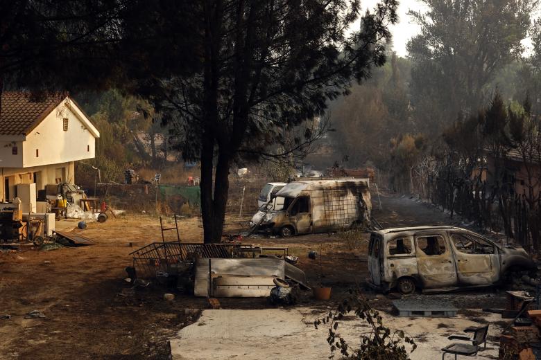 Varios coches calcinados yacen en el patio de una vivienda tras el incendio forestal que arrasó Pelayos de la Presa, a 65 kilómetros al oeste de Madrid, el 26 de julio de 2026.