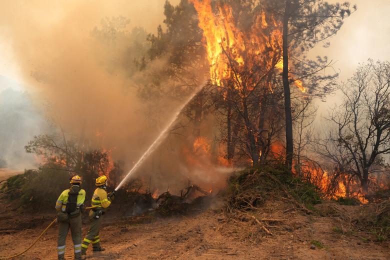 Los bomberos combaten un incendio que rodea la zona residencial de La Atalaya, en El Tiemblo, a 80 km al oeste de Madrid, el 25 de julio de 2026, en medio de los incendios forestales que han arrasado hasta 25 000 hectáreas.