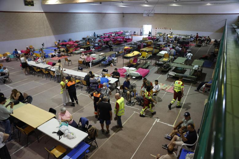 Personas alojadas en un polideportivo de la localidad madrileña de Villamanta, una de las localidades que se han convertido en uno de los puntos de acogida que la Comunidad de Madrid mantiene activos para acoger a evacuados por los incendios de la sierra oeste de la Comunidad de Madrid que continúa activo y sin estabilizar