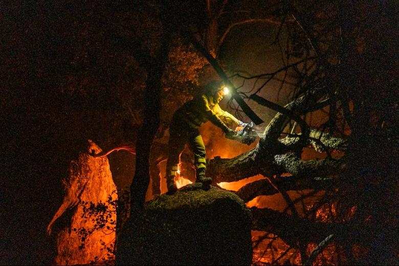 Una persona trabaja en las labores de extinción del incendio forestal, en La Adrada, (Ávila) en las primeras horas de este domingo