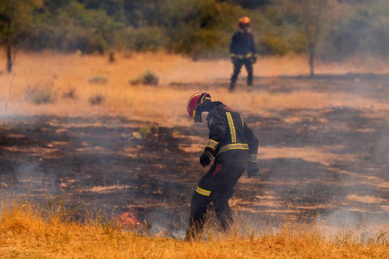 Un bombero de la Comunidad de Madrid intenta apagar las llamas con los pies durante un incendio forestal que arrasa cerca de San Martín de Valdeiglesias, a unos 70 km al oeste de Madrid, el 26 de julio de 2026.