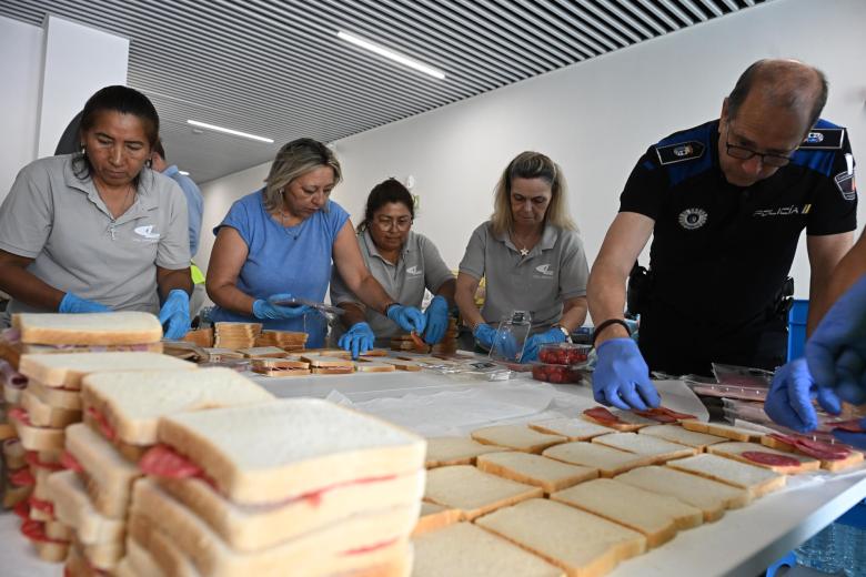 Voluntarios preparan comida para los vecinos de las localidades desalojadas por el incendio de la sierra oeste de la Comunidad de Madrid que permanecen en un polideportivo de Las Rozas, que se ha convertido en una de los puntos activos de acogida de la Comunidad de Madrid.
