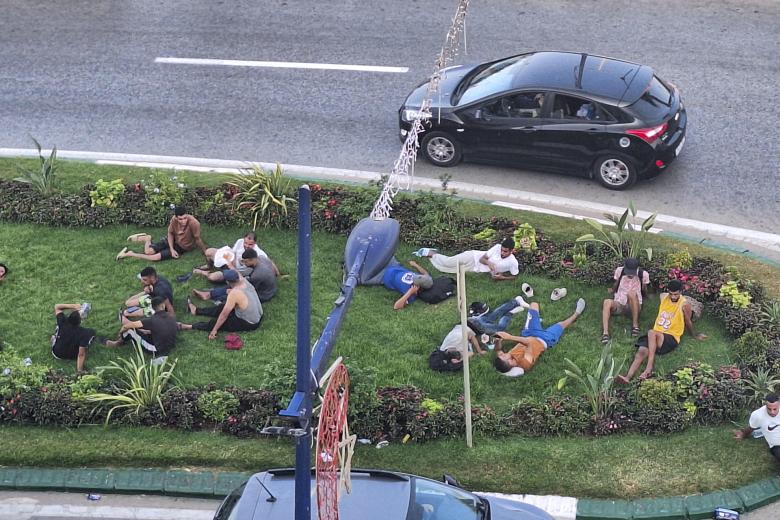 Varios migrantes descansan en una rotonda en Castillejos.