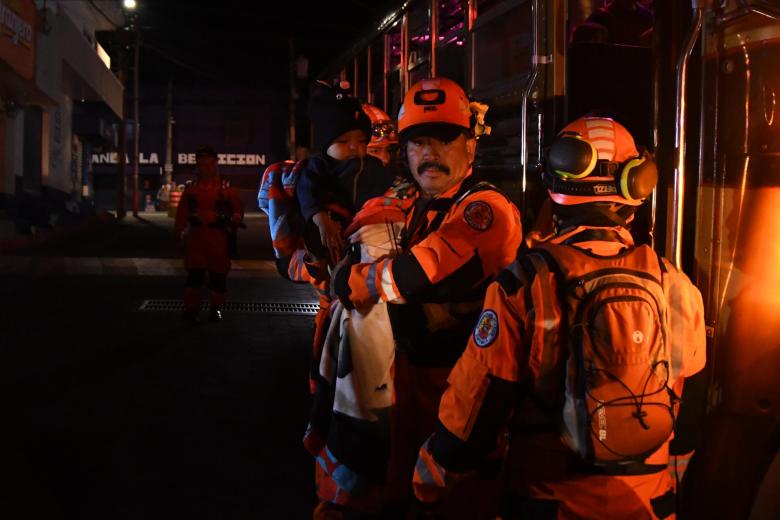 Integrantes de organismos de socorro evacuan a un niño este martes, en Alotenango al suroeste de Ciudad de Guatemala (Guatemala). La Coordinadora Nacional para la Reducción de Desastres (Conred) detalló que fueron evacuadas al menos dos aldeas, El Porvenir y Las Lajitas, que se encuentran en las faldas del volcán de Fuego