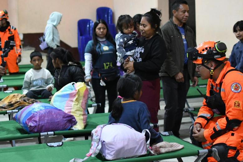 Personas descansan tras ser evacuadas este martes, en Alotenango al suroeste de Ciudad de Guatemala (Guatemala)