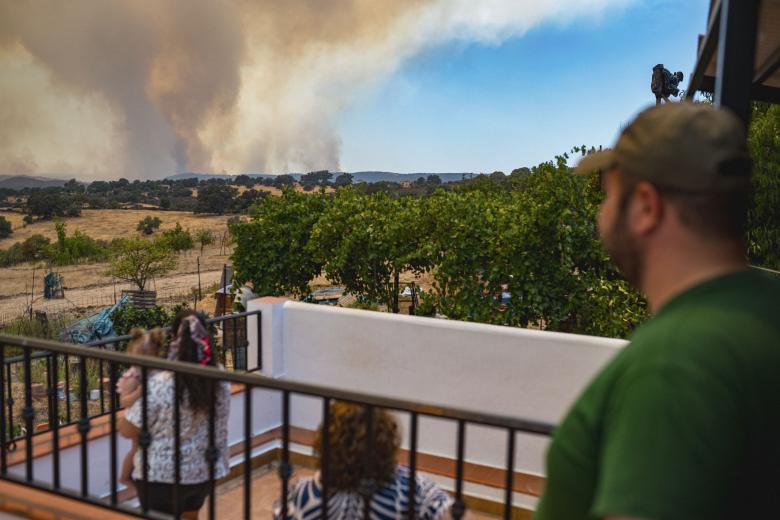 Vecinos de El Madroño (Sevilla) y efectivos policiales durante la evacuación del municipio, debido al incendio de Niebla (Huelva), que ha afectado a más de 20.000 hectáreas y continúa activo