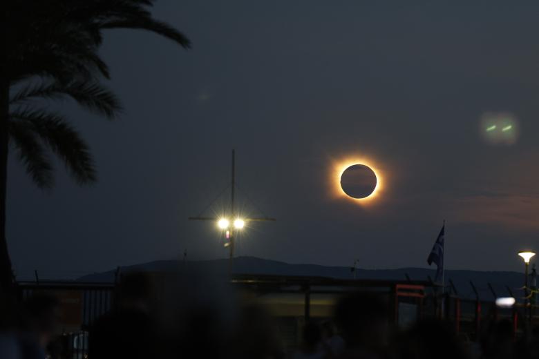 La corona solar resplandece mientras la Luna oculta totalmente el Sol durante la fase de totalidad del eclipse solar total, visto desde la playa del Arenal en Llucmajor, en Mallorca.