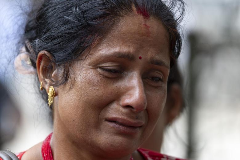 Una mujer llora a las puertas del hospital tras una riada repentina en Trishuli Bazar, distrito de Nuwakot (Nepal)