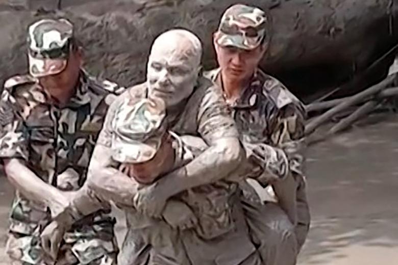 Un militar rescatando a un hombre que había quedado atrapado debido a las graves inundaciones y deslizamientos de tierra en la frontera entre Nepal y el Tíbet.